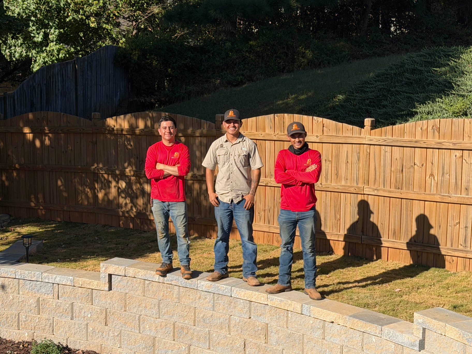 M&M Outdoor Solutions crew standing together at a completed retaining wall